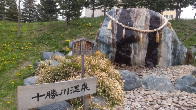 十勝川温泉の源泉を示す石碑と自然に囲まれた景観