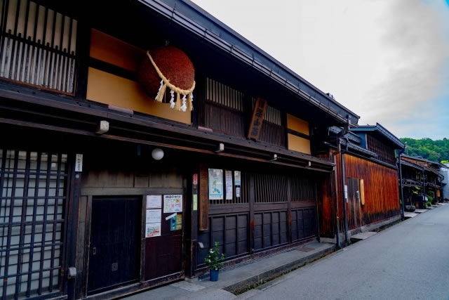 飛騨高山の古い町並みにある酒蔵の建物と軒先に下がる杉玉