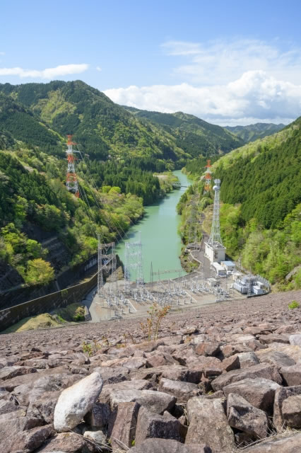 岩屋ダムの頂上（天端）から下流の馬瀬川を見下ろした絶景。ロックフィルダム特有の巨大な石の斜面と山々のパノラマ。