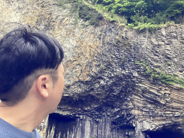 Hiroshi Akiyama gazing at the massive basalt columns at Genbudo Caves.